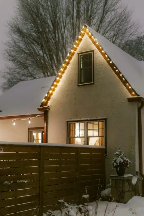 House decorated with Christmas lights in the snow