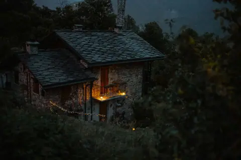 Stone cottage with glowing balcony lights at night