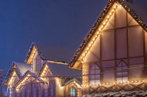 Row of houses covered in Christmas lights